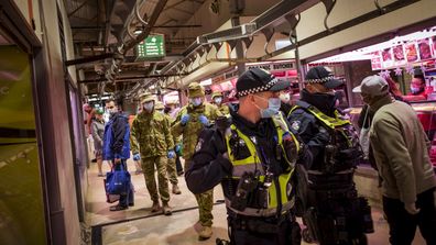 Members of Victoria Police aided by ADF soldiers patrol the Queen Victoria Market in Melbourne