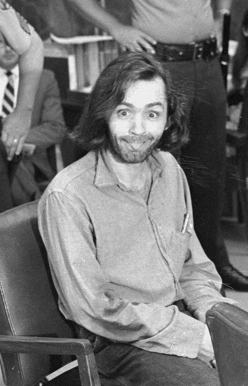 Charles Manson sticks his tongue out at photographers as he appears in a Santa Monica courtroom on June 25, 1970. (AP Photo)