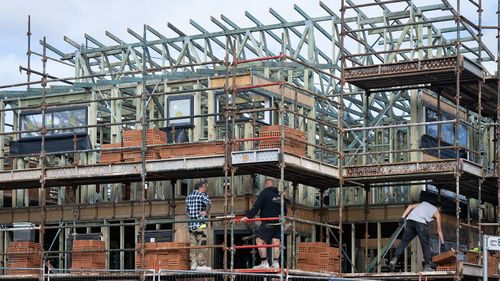 Costruzione di alloggi generici nel sobborgo esterno di Austral a Sydney. Nuove case, mestieri, edilizia, muratori, manovali, lavoro, economia, accessibilità degli alloggi, espansione urbana, strade, quartieri. 