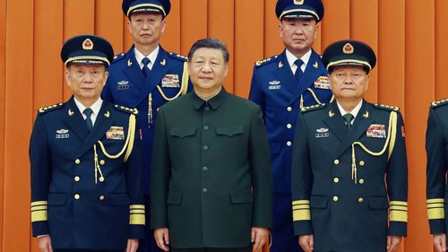 Chinese President Xi Jinping, also chairman of the Central Military Commission (CMC), front row second from left, poses with other military officers after promoting to generals, back row, from left, Yang Zhibin of the Eastern Theater Command and Han Shengyan commander of Central Theater Command in Beijing on Monday, Dec. 22, 2025. (Li Gang/Xinhua via AP)
