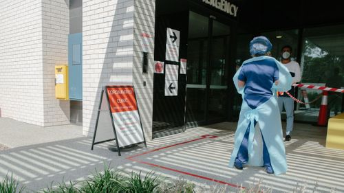 A medical staff member talks to someone in line at the Coronavirus clinic at the Northern Beaches Hospital.