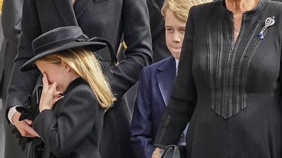 Kate, Princess of Wales, from left, Princess Charlotte, wiping her eye, Prince George, Camilla, the Queen Consort and Meghan, Duchess of Sussex follow the coffin of Queen Elizabeth II following her funeral service in Westminster Abbey in central London Monday Sept. 19, 2022. The Queen, who died aged 96 on Sept. 8, will be buried at Windsor alongside her late husband, Prince Philip, who died last year. (AP Photo/Martin Meissner, Pool)