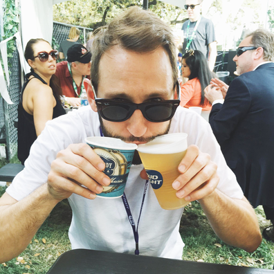 Man drinking two beers outdoors