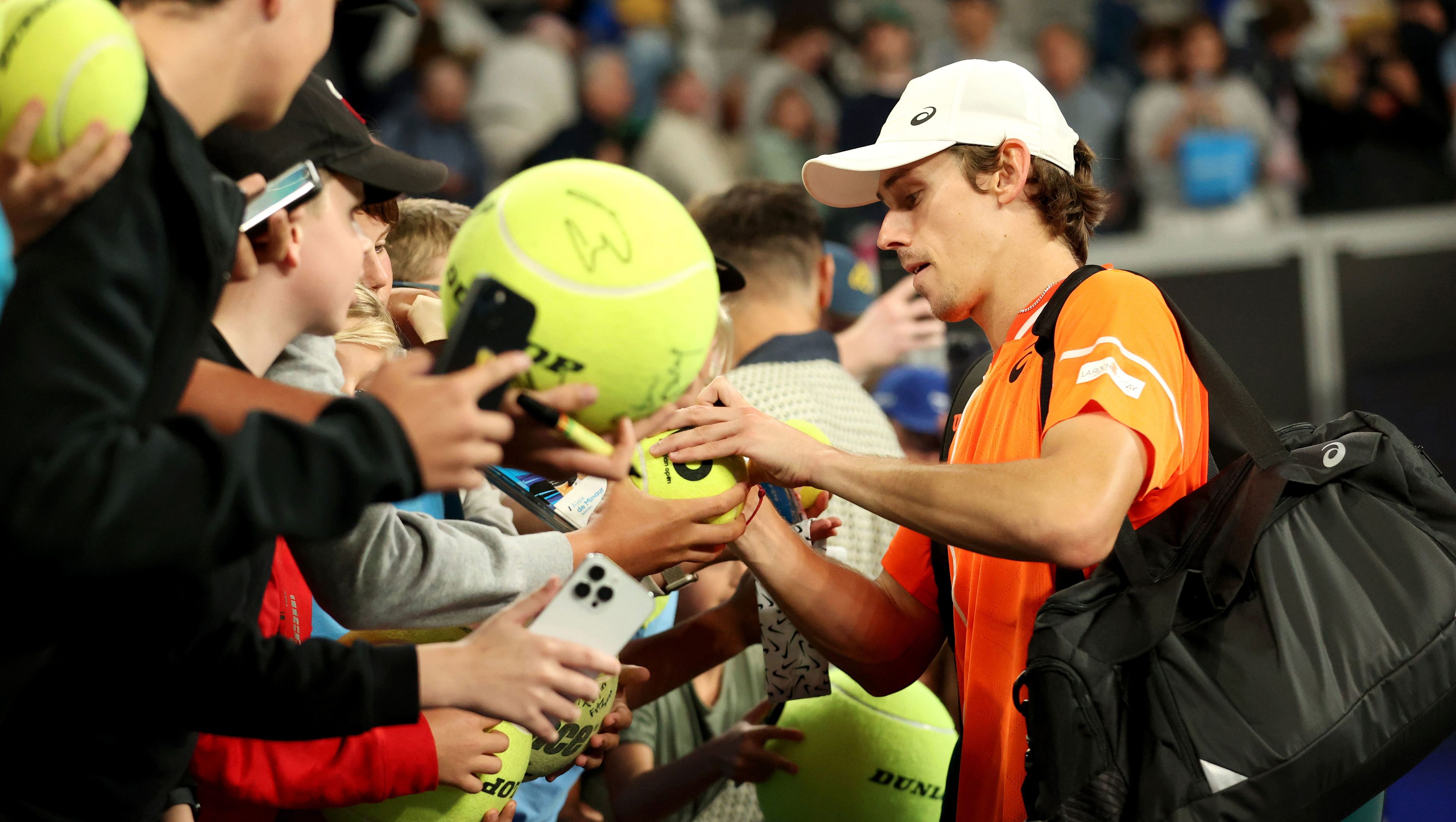 Alex de Minaur signs autographs for fans after his third round win at the Australian Open.