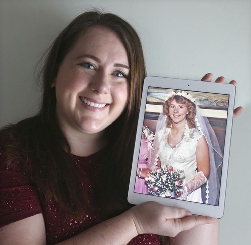 Ame Bartlebaugh found Mrs Harvilla's dress in her grandmother's storage space. Ms Bartlebaugh is seen here holding a 1980 photo of her mother in her wedding dress in Willowick. (AAP)