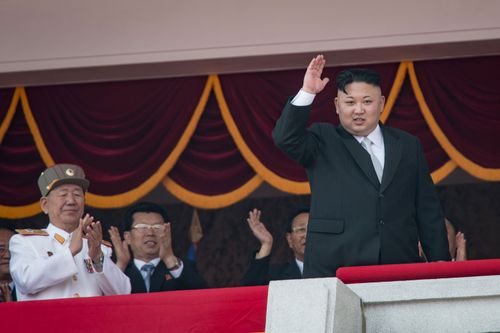 North Korean leader Kim Jong-Un (R) waves from a balcony of the Grand People's Study house following a military parade marking the 105th anniversary of the birth of late North Korean leader Kim Il-Sung, in Pyongyang on April 15, 2017.  