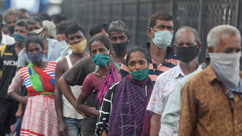 Homeless people stand in a queue  during a food distribution in Mumbai, India, Saturday, June 20, 2020. (AP Photo/Rafiq Maqbool)