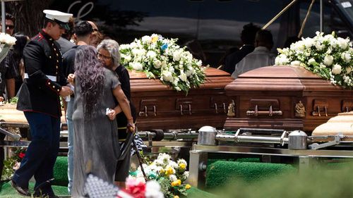 Two women comfort each other during the burial service for Irma Garcia and her husband Joe Garcia in Uvalde, Texas.