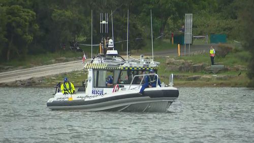 A woman has died and p﻿olice are urgently searching for two children in a south-west Sydney bay.