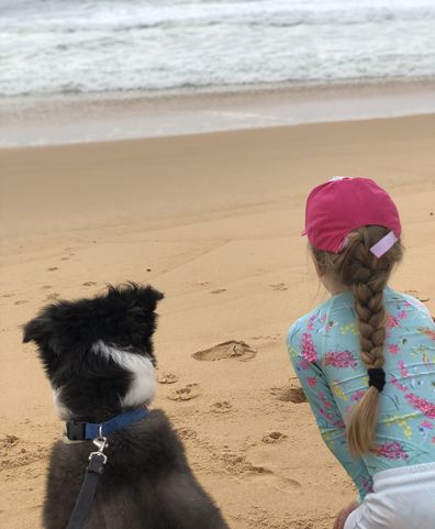 Holidaying with pets, dog and girl on beach