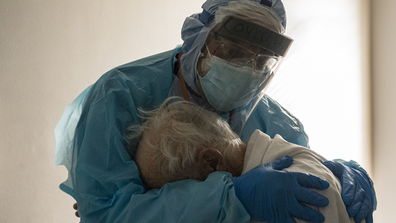 Dr. Joseph Varon comforts a patient in the COVID-19 intensive care unit at the United Memorial Medical Center in Houston, Texas.