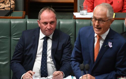 The deputy prime minister listens on as Malcolm Turnbull is forced to defend him in question time (AAP)