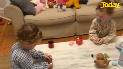 After saying 'Hi' to their Dad, the twins returned to their tea party. 