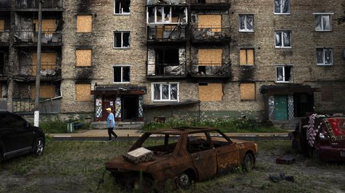 A resident walks past an apartment building heavily damaged in Russian attacks in Irpin, Ukraine.