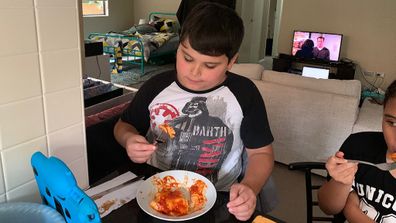 Giovanni with autism eating lasagne.