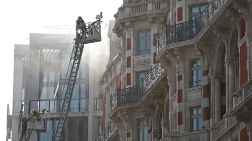 Fire crews try to extinguish the fire which started on the roof. (AAP)