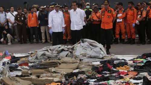 Indonesian President Joko Widodo views debris collected after the two-month-old plane plummeted into the ocean.