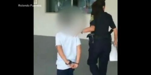 Video footage captures the young boy with his hands cuffed behind his back.