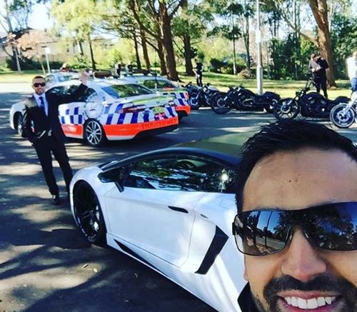 Wedding guest Ibrahim Azam in front of  sports car and the police cars blocking the street. (Instagram)