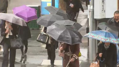 Umbrellas were a must have item in the city this afternoon. (9NEWS)