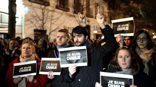 Demonstrators hold pencils during a rally outside France's embassy in Madrid, Spain in solidarity with the slain Charlie Hebdo employees. (AAP)