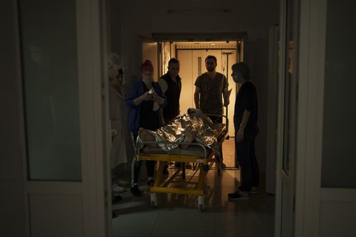 Medical staff transfer an injured Ukrainian soldier to the operating room as the Russian attack continues in Kharkiv, Ukraine, Friday, March 25, 2022 