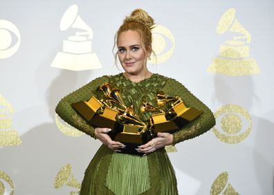 Adele poses in the press room with the awards for album of the year for "25," song of the year for "Hello," record of the year for "Hello," best pop solo performance for "Hello," and best pop vocal album for "25" at the 59th annual Grammy Awards on Feb. 12, 2017, in Los Angeles. 