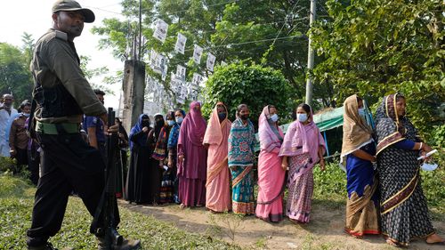 Voters wait in a queue outside a polling centre in Srinagar, Munshiganj district, Bangladesh, during village council elections in 2021 which was boycotted by the BNP.