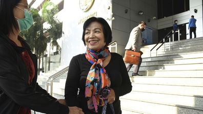 A woman identified only by her first name Anchan, right, talks to her friend as she arrives at the Bangkok Criminal Court in Bangkok, Thailand, Tuesday, Jan. 19, 2021