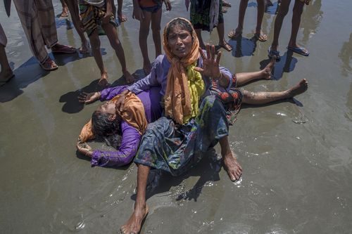 A Rohingya Muslim woman, who crossed over from Myanmar into Bangladesh, shouts for help as a relative lies unconscious after the boat they were travelling in capsized minutes before reaching shore. (AP)