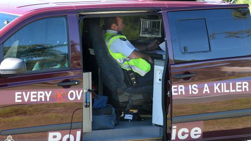 A police officer sits inside a mobile speed camera on the Gold Coast. (Image: AAP)