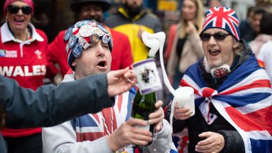 Royal fans celebrate in the streets of Windsor popping bottles of champagne upon the announcement of baby Sussex's birth