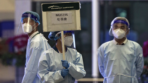 A worker from the China Eastern holds a signboard waiting to lead relatives of the victims aboard China Eastern's flight MU5735 to a cordoned off area, in Guangzhou Baiyun International Airport in Guangzhou.