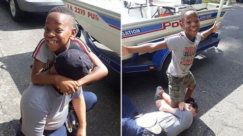 Boy poses with police officer who saved his wrestling belt from Louisiana floodwaters