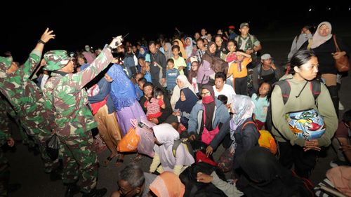 Thousands of desperate Indonesian earthquake and tsunami survivors have converged on Palu's airport in a bid to leave the devastated city