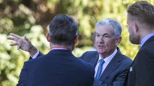 Federal Reserve Chairman Jerome Powell, center, drinks coffee with attendees of the central bank's annual symposium at Jackson Lake Lodge in Grand Teton National Park on Friday, Aug. 26, 2022 in Moran, Wyoming.  (AP Photo/Amber Baesler)
