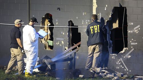 FBI agents examine the back wall of the Pulse nightclub. Source: AFP