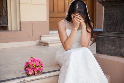 Hopeless bride crying outside a church after being stood up on her wedding day