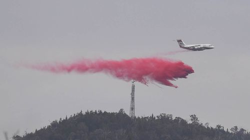 A water bombing airplane is seen dropping fire retardant at the Pierces Creek fire near Canberra, Friday, November 2, 2018.