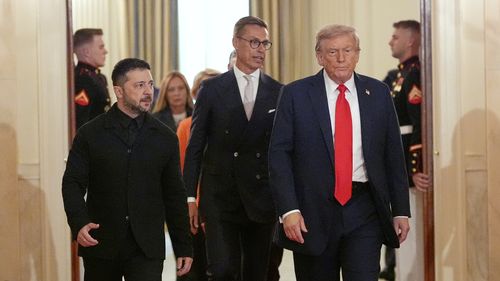Ukraine's President Volodymyr Zelenskyy, from left, Finland's President Alexander Stubb and President Donald Trump walk through the Cross Hall of the White House, Monday, Aug. 18, 2025, in Washington.
