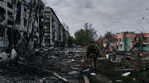 Un soldat ukrainien passe devant des maisons détruites par les bombardements russes à Bakhmut, dans la région de Donetsk, en Ukraine.