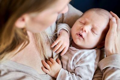 Close-up of caring mother lovingly holding her newborn baby in a close embrace