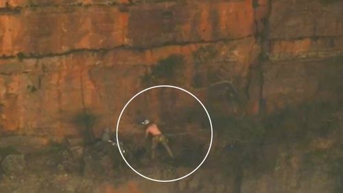 An injured rock climber hangs off a Blue Mountains cliff, waiting to be winched to safety by a rescue helicopter.