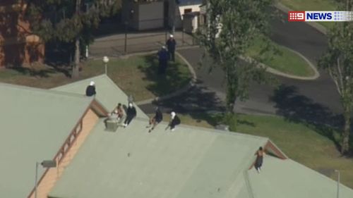 The inmates on the roof of a Melbourne Youth Justice Centre building. (9NEWS)