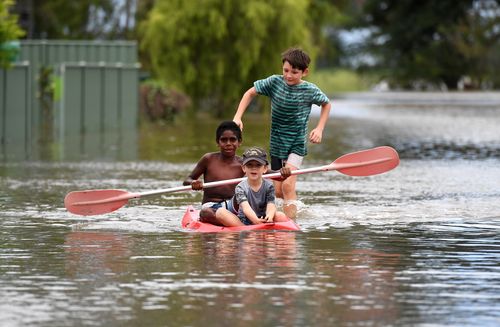 Children play in flood waters in Ingham (AAP)