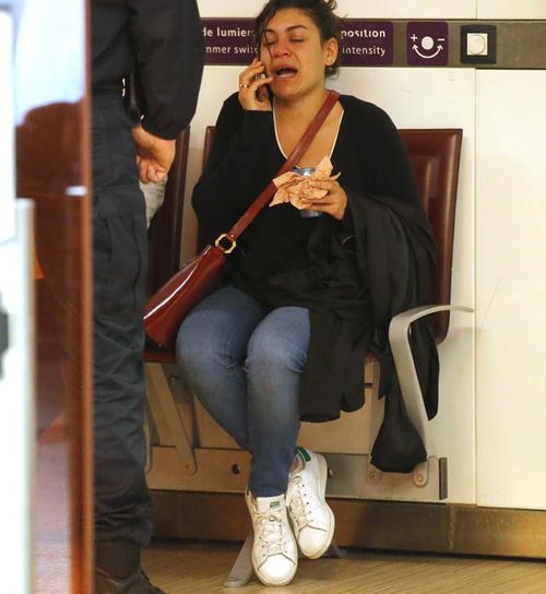 A relative of a passenger frantically phones loved ones at Charles de Gaulle airport in Paris. (AAP)
