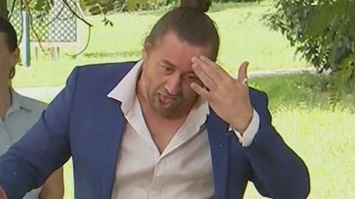 AUSLAN interpreter Mikey Webb wipes his brow following a bird's contribution to the Queensland press conference.