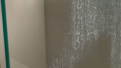 Shower with hard water stains after being cleaned with a melamine sponge by The Clean Group