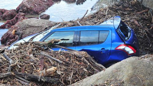 A car washed onto the rocks at Stanwell Park beach yesterday.