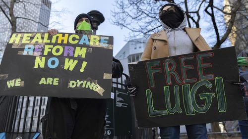 Luigi Mangione supporters hold signs outside the Supreme Court on Friday, Feb. 21, 2025 in New York. (AP Photo/Stefan Jeremiah)